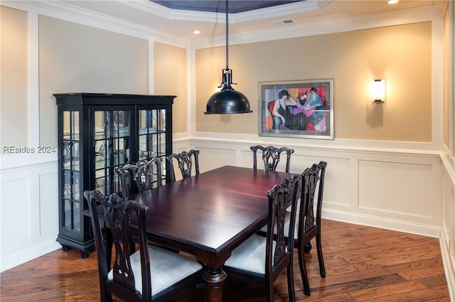 dining space featuring crown molding, dark hardwood / wood-style flooring, and a raised ceiling