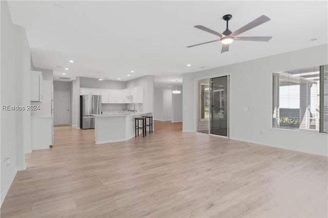 unfurnished living room with ceiling fan and light wood-type flooring