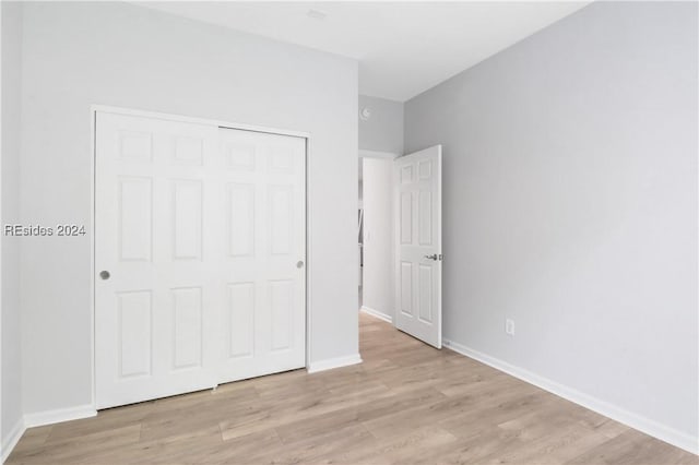 unfurnished bedroom with light hardwood / wood-style floors and a closet