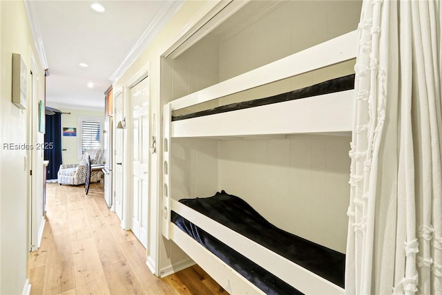 hallway featuring crown molding and light hardwood / wood-style floors