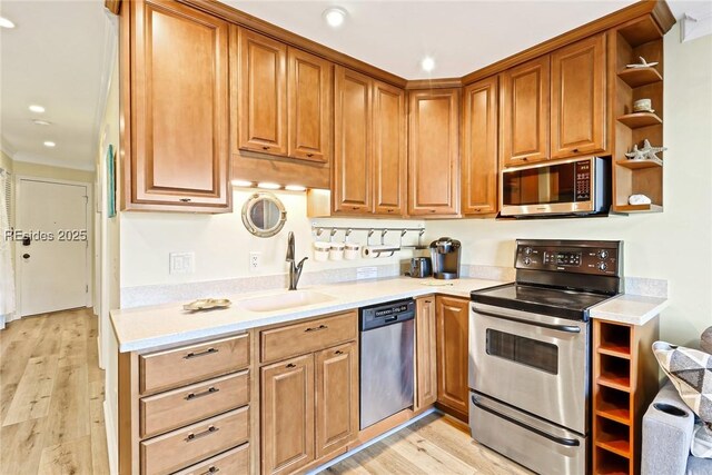 kitchen with stainless steel appliances, light hardwood / wood-style floors, and sink