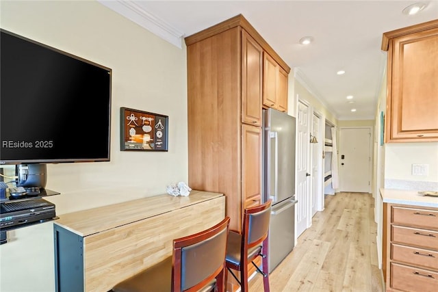 kitchen with ornamental molding, stainless steel fridge, and light wood-type flooring