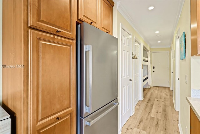 kitchen featuring light hardwood / wood-style flooring, stainless steel fridge, and ornamental molding