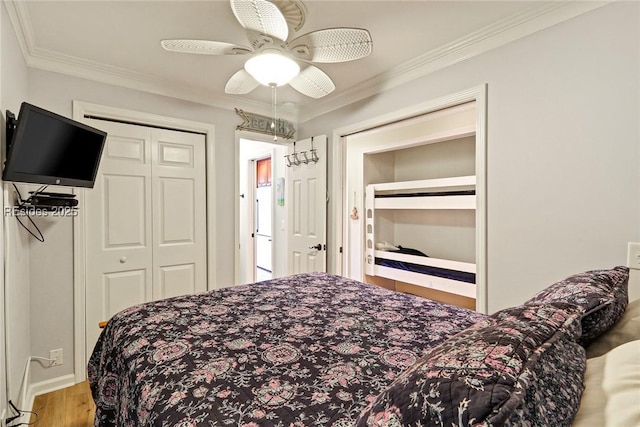 bedroom featuring hardwood / wood-style flooring, crown molding, ceiling fan, and a closet