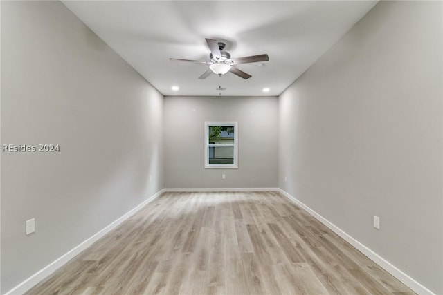 empty room with ceiling fan and light hardwood / wood-style flooring