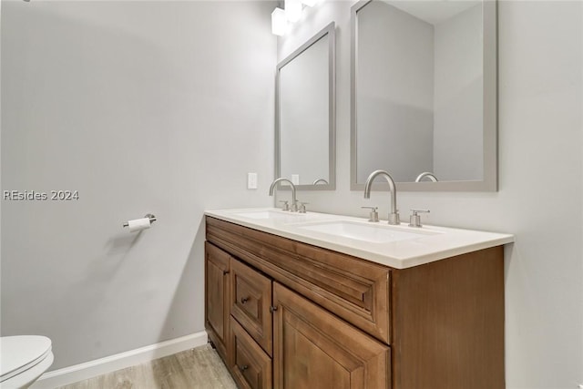 bathroom with vanity, hardwood / wood-style floors, and toilet