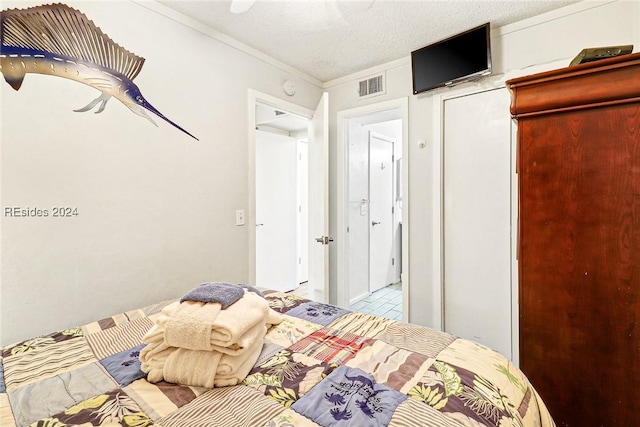 unfurnished bedroom with ceiling fan, ornamental molding, and a textured ceiling