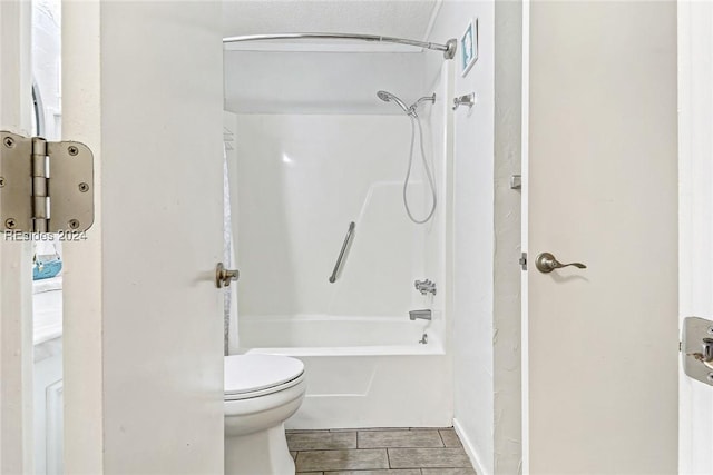 bathroom featuring shower / tub combination and toilet