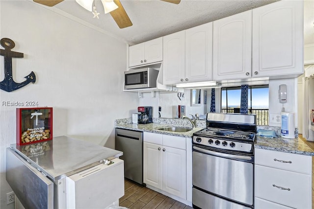 kitchen featuring stainless steel appliances, sink, white cabinets, and light stone counters