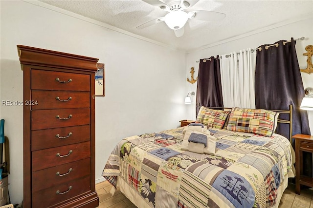 bedroom with a textured ceiling, ceiling fan, and light hardwood / wood-style flooring