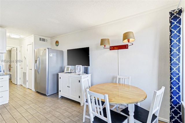 dining area featuring crown molding and a textured ceiling