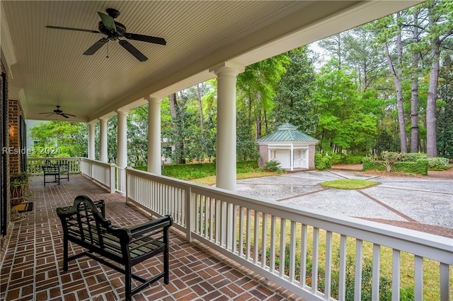 view of patio / terrace featuring ceiling fan, an outdoor structure, and covered porch