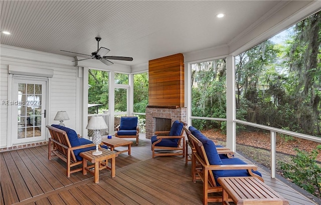 sunroom / solarium with an outdoor brick fireplace, ceiling fan, and a healthy amount of sunlight