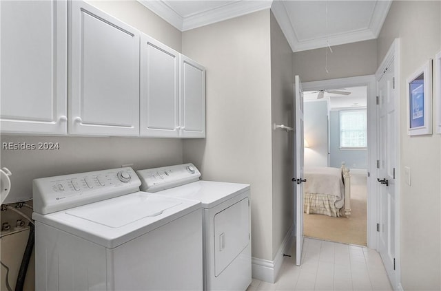 washroom with cabinets, ornamental molding, and washer and dryer