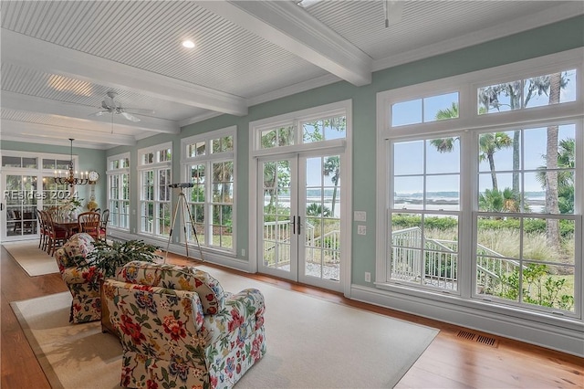 sunroom / solarium with french doors, beam ceiling, and ceiling fan with notable chandelier