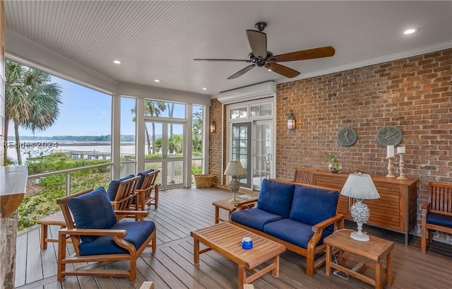 sunroom / solarium with a water view and ceiling fan