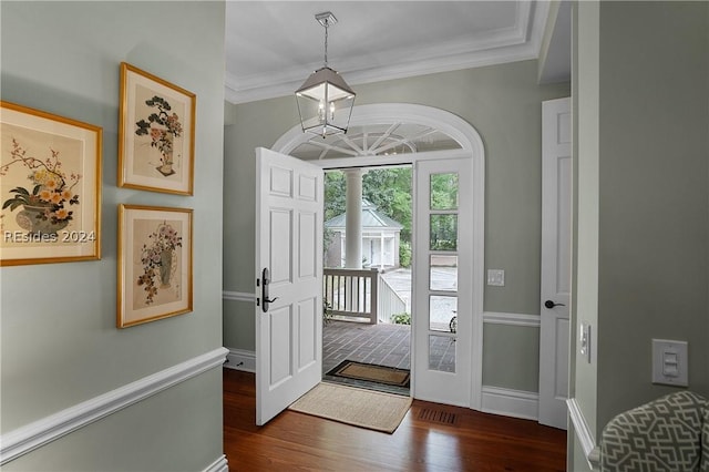 foyer entrance featuring crown molding, a notable chandelier, and dark hardwood / wood-style flooring