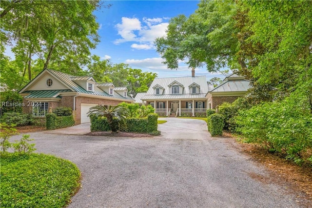 cape cod home with a garage and a porch