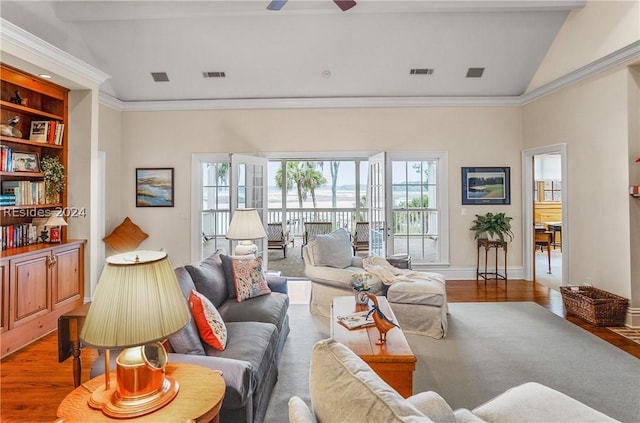 living room featuring hardwood / wood-style flooring, ornamental molding, ceiling fan, and lofted ceiling with beams