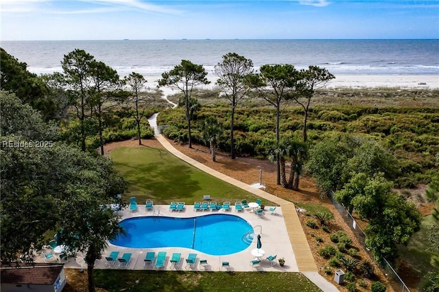 view of pool featuring a water view, a yard, and a patio area