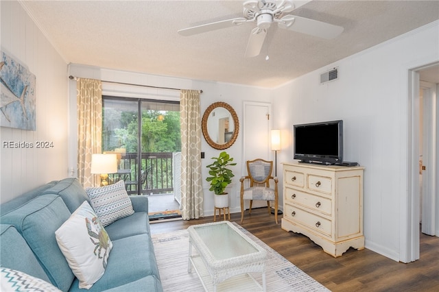 living room featuring crown molding, ceiling fan, dark hardwood / wood-style flooring, and a textured ceiling