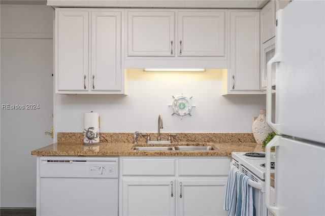 kitchen featuring sink, light stone counters, white cabinets, and white appliances