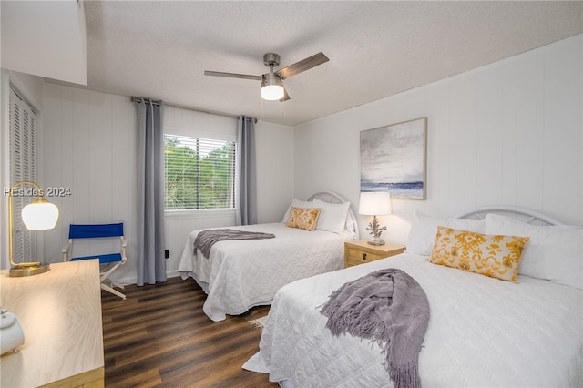 bedroom featuring ceiling fan, dark hardwood / wood-style floors, and a textured ceiling