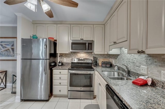 kitchen featuring light tile patterned flooring, appliances with stainless steel finishes, sink, decorative backsplash, and cream cabinets