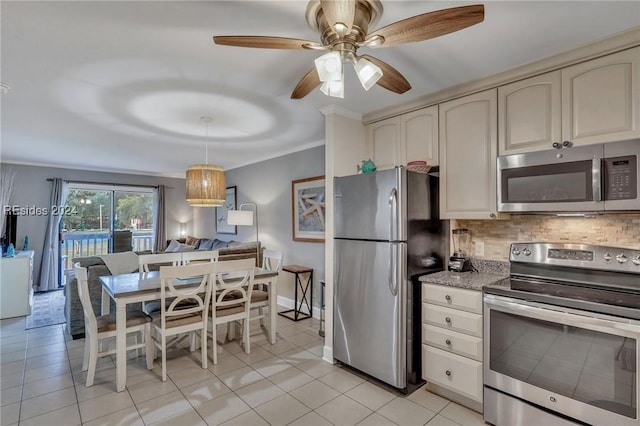 kitchen featuring tasteful backsplash, light tile patterned floors, ornamental molding, appliances with stainless steel finishes, and cream cabinetry