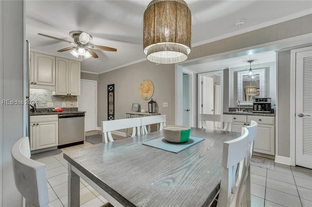 tiled dining area featuring crown molding, sink, and ceiling fan