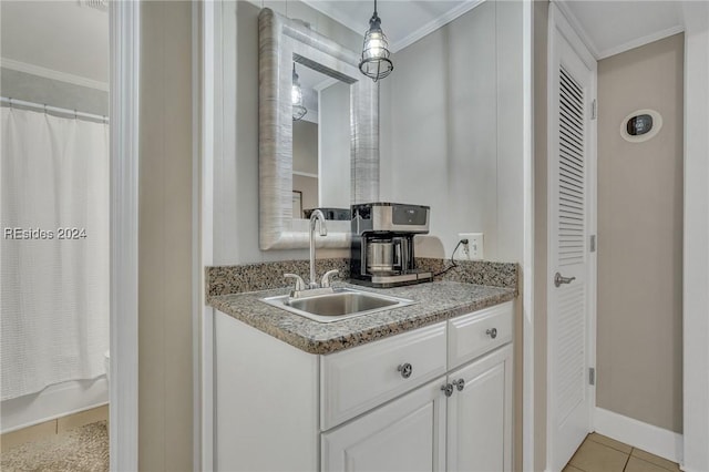 kitchen with sink, crown molding, white cabinets, light tile patterned flooring, and decorative light fixtures