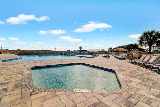 view of swimming pool with a water view and a patio area