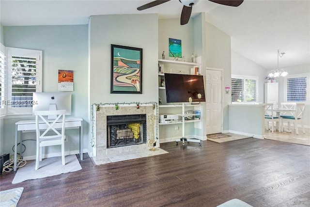 living room featuring hardwood / wood-style flooring, a premium fireplace, lofted ceiling, and ceiling fan with notable chandelier