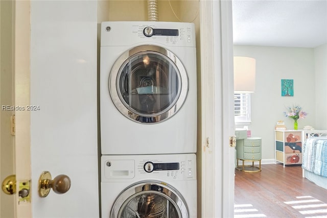 washroom featuring stacked washer and dryer and light wood-type flooring