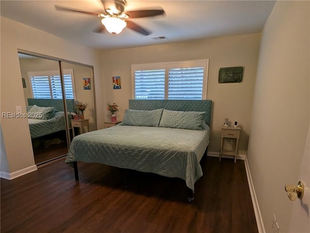 bedroom with multiple windows, dark hardwood / wood-style floors, ceiling fan, and a closet