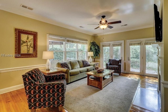 living room with ceiling fan, ornamental molding, and light hardwood / wood-style flooring