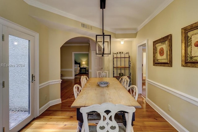 dining space featuring ornamental molding, light hardwood / wood-style floors, and plenty of natural light