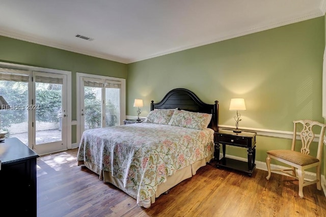 bedroom with hardwood / wood-style flooring, ornamental molding, and access to outside