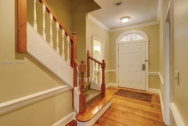 foyer entrance featuring crown molding and hardwood / wood-style floors