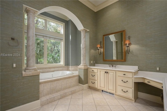 bathroom with tile patterned floors, ornamental molding, vanity, tiled bath, and decorative columns