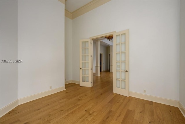 unfurnished room with french doors, ornamental molding, and light hardwood / wood-style floors