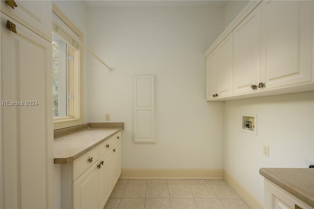 washroom with cabinets, washer hookup, and light tile patterned floors