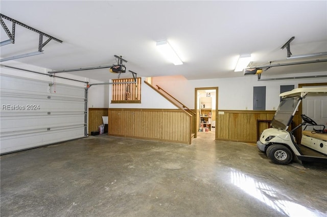 garage with a garage door opener, wooden walls, and electric panel