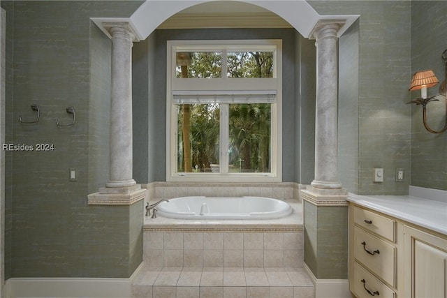 bathroom featuring vanity, tiled tub, and ornate columns