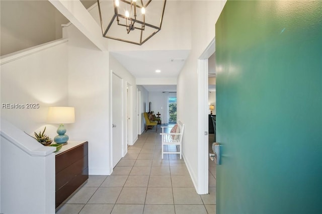 hallway featuring light tile patterned floors and a chandelier