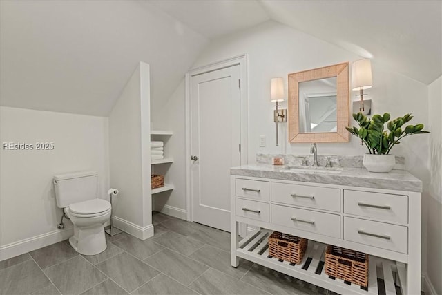 bathroom featuring lofted ceiling, toilet, and vanity