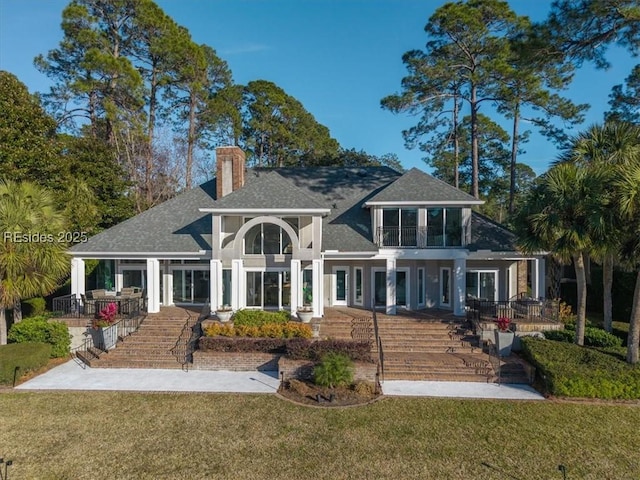 rear view of house featuring a yard and covered porch