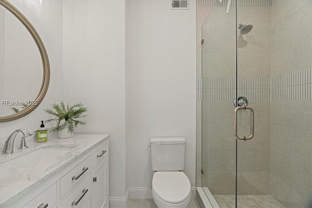 bathroom with vanity, toilet, and a shower with shower door