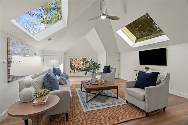 living room with ceiling fan, lofted ceiling with skylight, and hardwood / wood-style floors