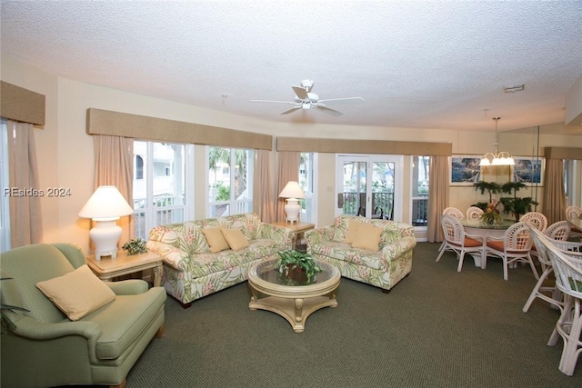 carpeted living room with ceiling fan with notable chandelier and a textured ceiling